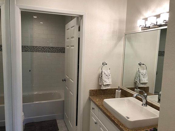 Bathroom with shower in tub and a sleek style.