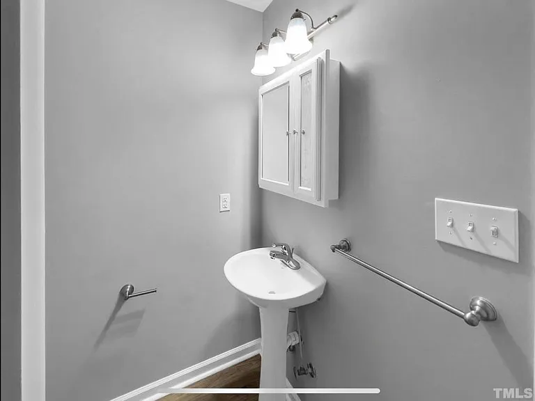 Two storage cabinets above sink and above toilet tank.