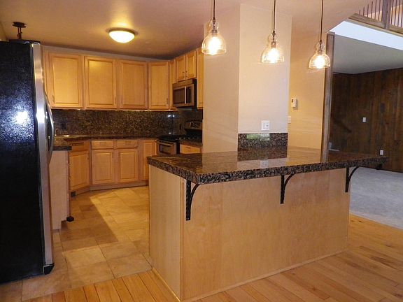 Modern, upgraded kitchen, with granite countertops/backsplash, and stainless steel appliances.