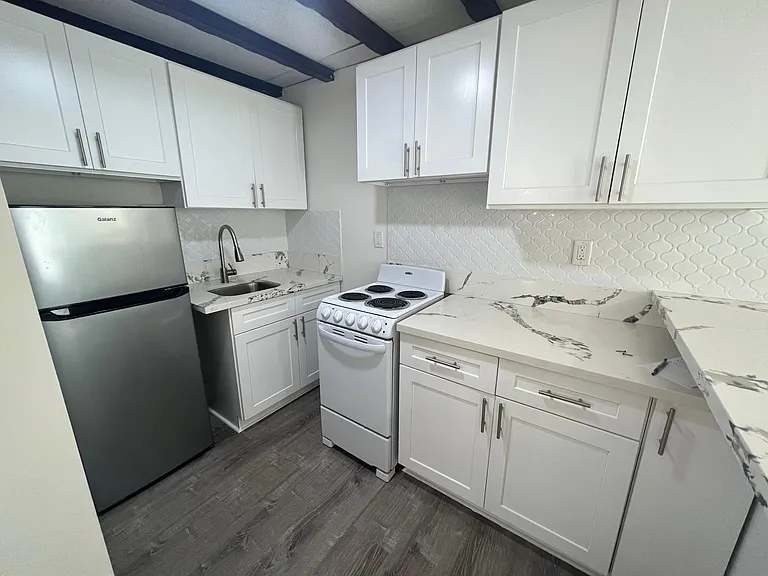 Kitchen up close. Electric stove / oven. Medium size fridge. Lots of cabinet space.
