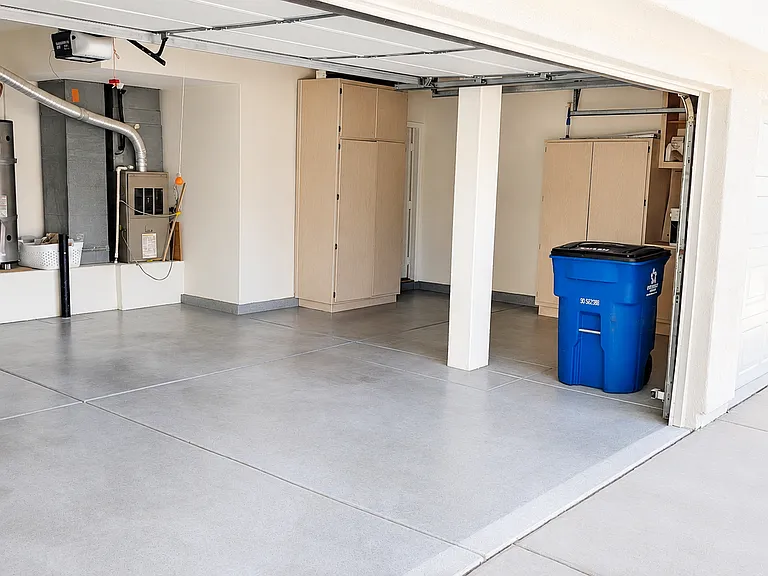 Attached garage with storage cabinets and clean finished flooring