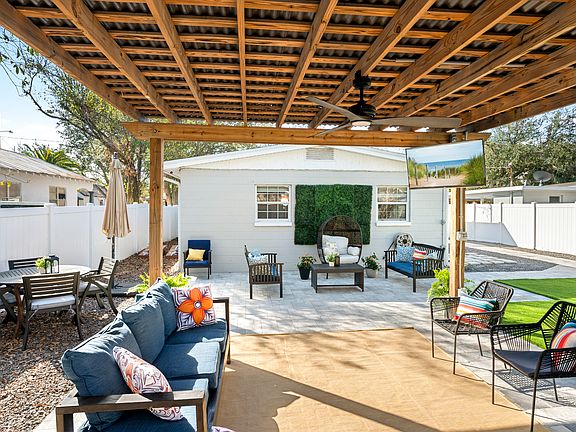 Outdoor Pergola with lots of seating, dining, and outdoor TV for entertainment