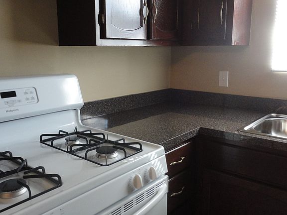 New stove, counters, and stainless steel sink and faucet.