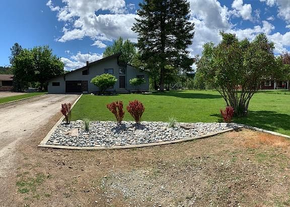 New landscaping at end of driveway with guest parking area.
