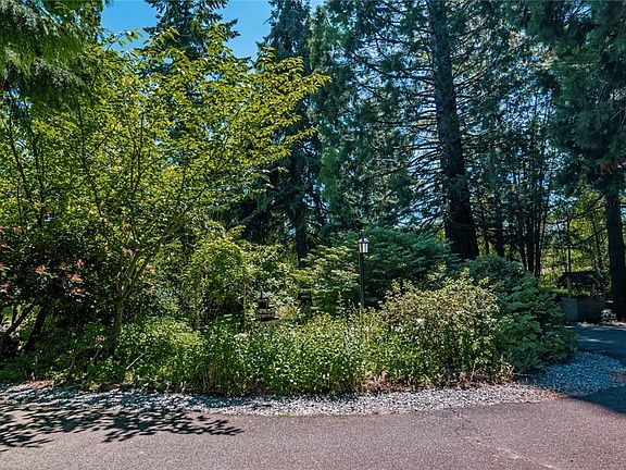 The paved circular drive offers plenty of parking & convenience. The lush established landscape is beautiful