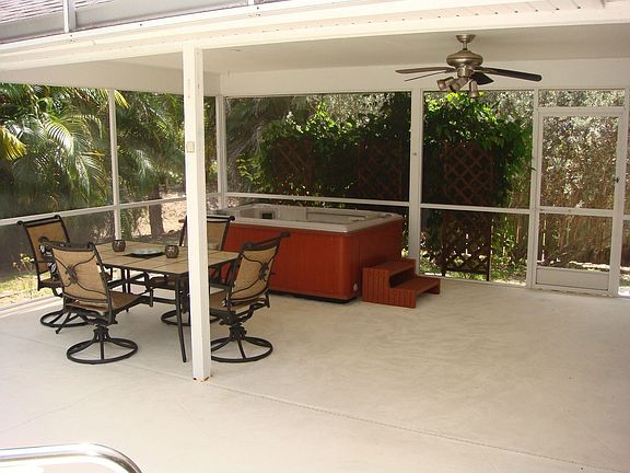 Relax under the roofed outdoor patio complete with a hot tub and screen cage.