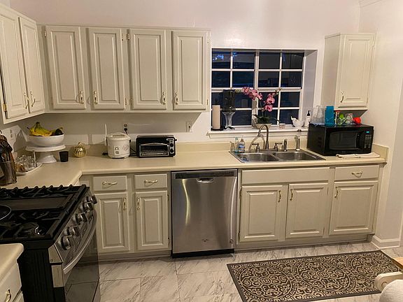 Spacious kitchen with window and stainless steel dishwasher