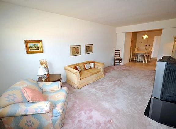 Large living room with covered hardwood floors.