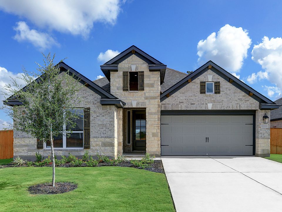 Exterior of the Caldwell with light brick and stone, a two-car garage, and professional landscaping.