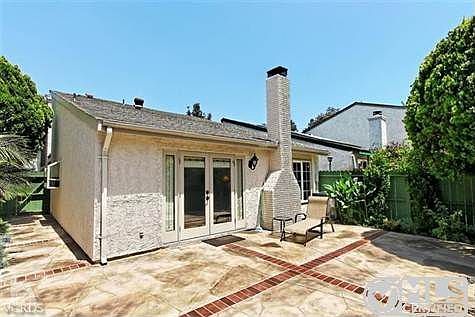 Brick ribboned stamped concrete patio enclosed by wood fencing. Gate to walkway, pool, spa and tennis courts.