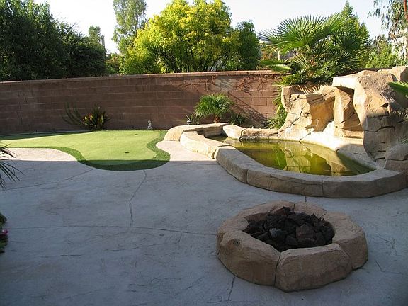 Great backyard with putting green, spa/waterfall and firepit