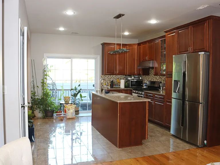 Open kitchen layout with stainless steel appliances with walk out deck door