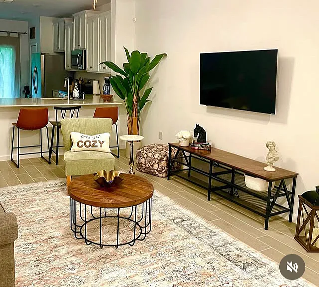 Relax and unwind in this inviting living room, featuring a cozy couch, sitting chairs and a coffee table perfect for conversations or movie nights.