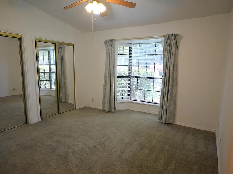 Bedroom with two closets & bay window. Blue curtains have been replaced.