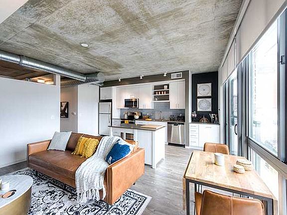 Open concept kitchen and living areas with hard surface flooring and floor to ceiling windows