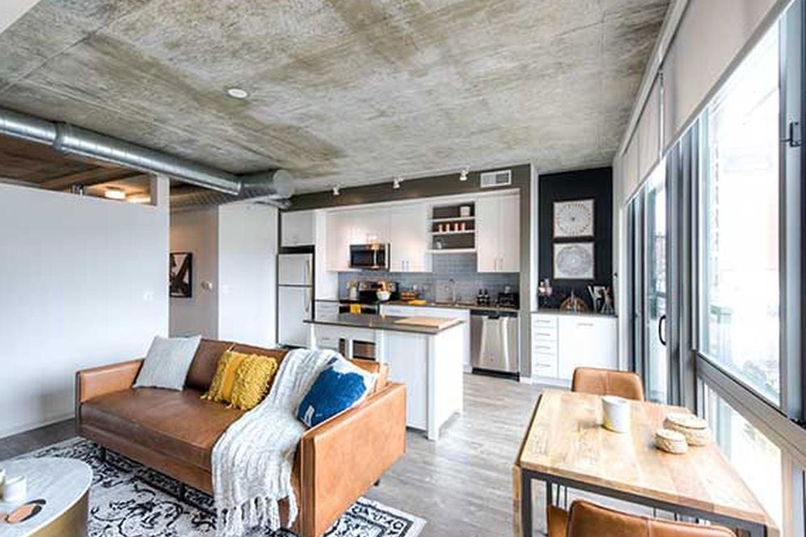 Open concept kitchen and living areas with hard surface flooring and floor to ceiling windows