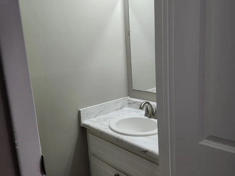 View upgraded sink, countertop, faucet and freshly painted cabinet. Linen closet on opposite side. Very good light.
