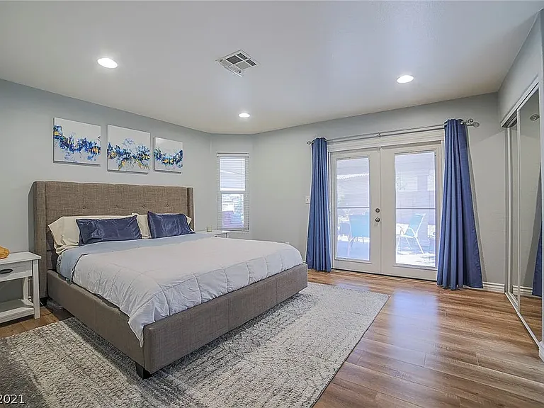 Primary suite, showing french doors to patio, one of 2 bedroom closets shown on right ride. Walk in closet is in primary bathroom.