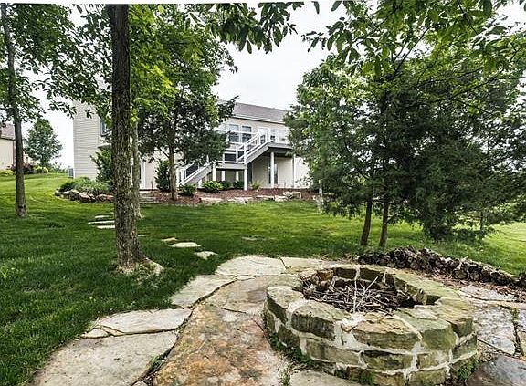 Large, private yard with deck, patio, water feature, and firepit.