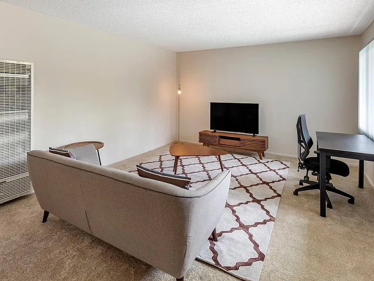 Furnished+ apartment homes come outfitted with a sofa, side chair, side table, coffee table, TV stand and 50" Television (Representative Image exact items and style of furnishings may vary)