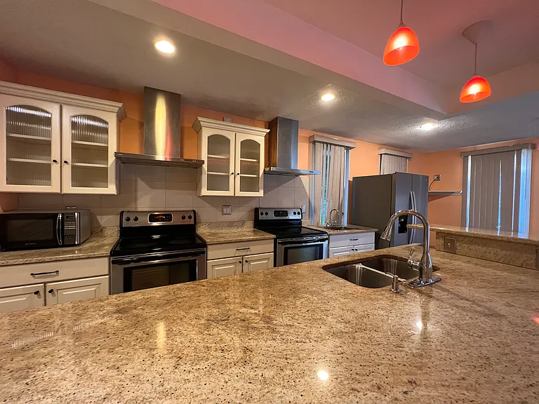 kitchen w/ granite countertops, 2 sinks & 2 stoves