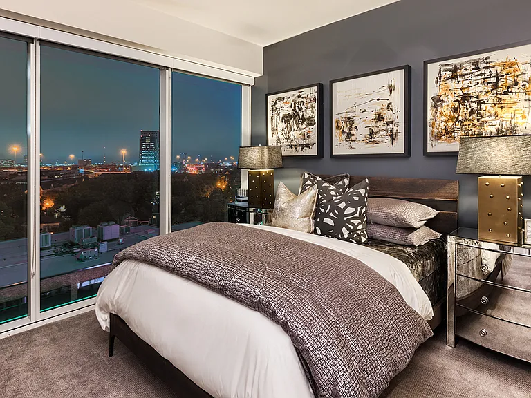 Cozy bedroom with expansive skyline views and plush carpet