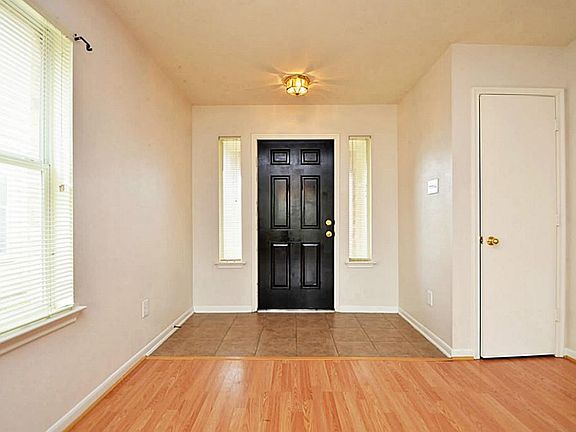 Welcoming view from the inside of the front entry door recently painted to den with laminate floors