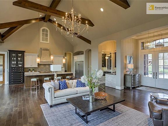 Double door entry opens up to this stunning great room.  You will love the high, beamed ceiling and wall of windows overlooking the treed lot.