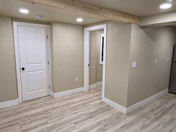 View from dining / living room to kitchen, front door, closet door, and entry to bathroom.