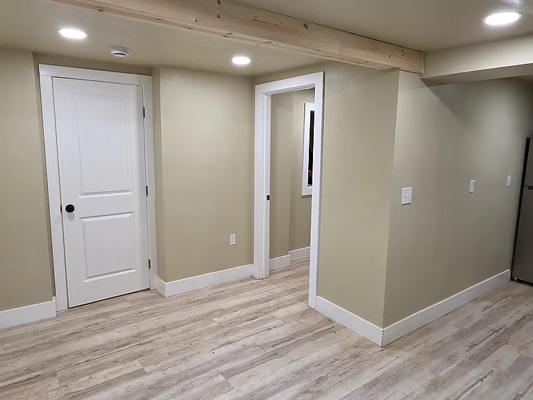 View from dining / living room to kitchen, front door, closet door, and entry to bathroom.