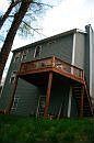 back view with deck on second floor with basement below