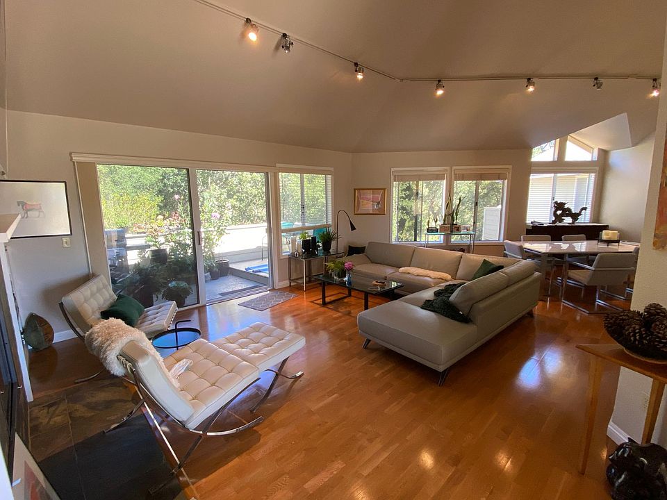 Spacious living area with many windows, leading to balcony.