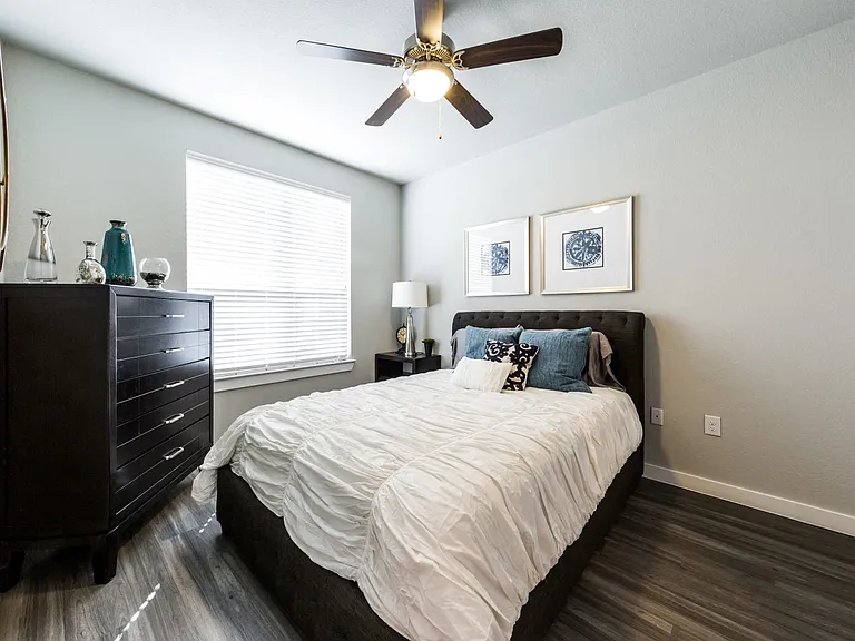 Bedroom one with wood-style flooring, ceiling fan and large bedside window