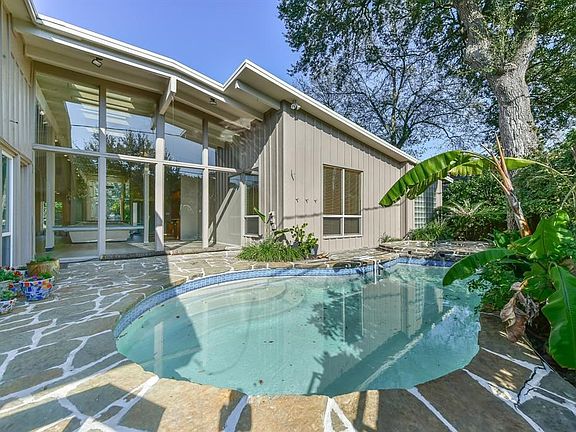 The one-story home has views throughout of the flagstone decking, pool and water feature.