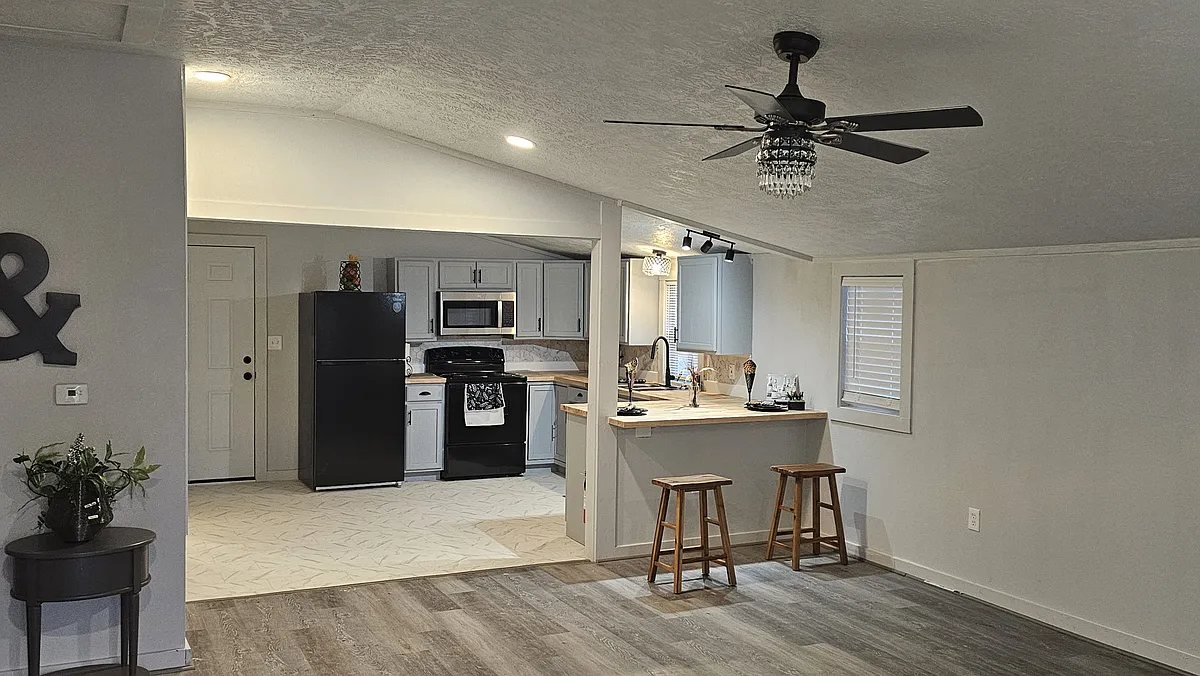 Spacious living area showcasing new flooring, neutral paint tones, updated windows with blinds - 715 Sabine St