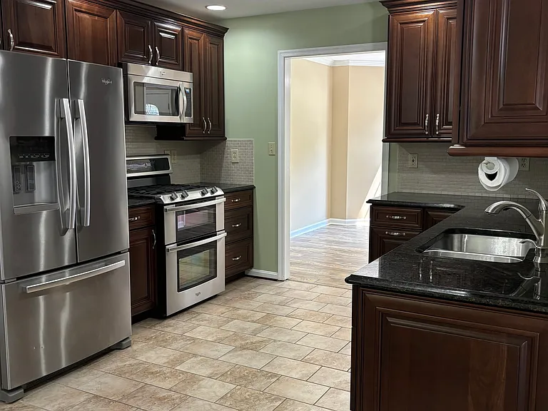 Refrigerator with ice and water dispenser. Microwave. Natural gas stove with 2 ovens. Recessed lights. Double sink. Undercabinet lighting. Stone tile floor.