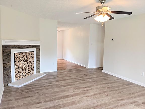 Living room with view of entrance to kitchen (center) and hallway to bedrooms (Right)