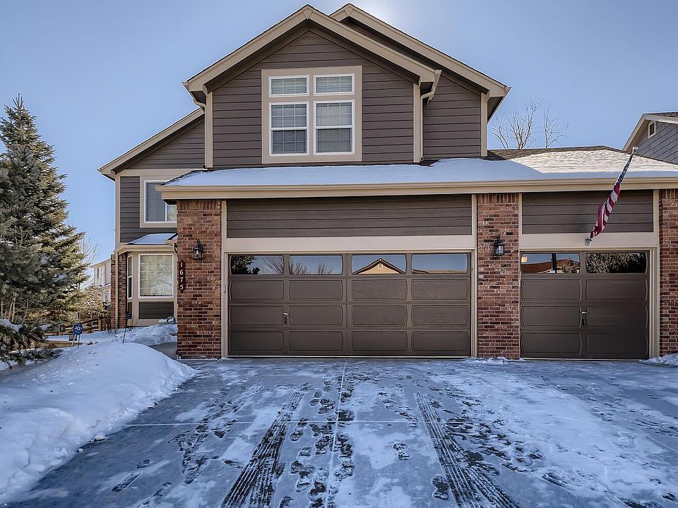 Front view of home. Three car garage, large mature pine trees in front yard.