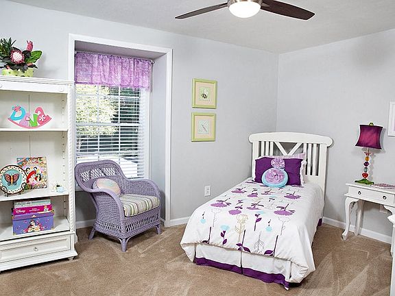 a bedroom with a bed, a dresser, and a window