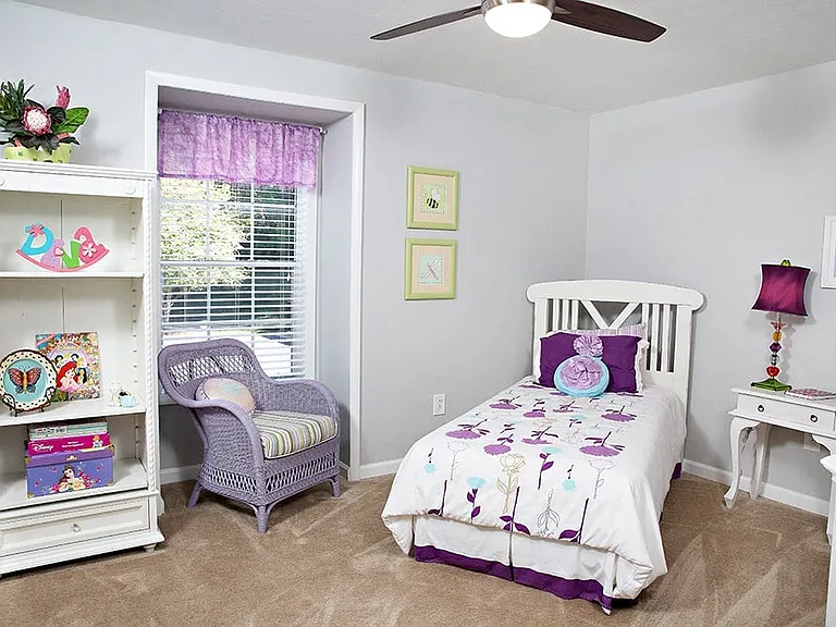 a bedroom with a bed, a dresser, and a window