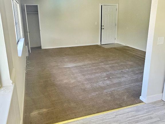 View of the living room from the kitchen. Lots of storage in the unit: - Storage closet in living room (pictured) - Hall closets - Bathroom closets - Storage above parking space