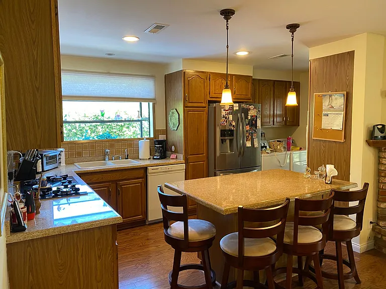 Kitchen with granite counters, center island and breakfast bar.