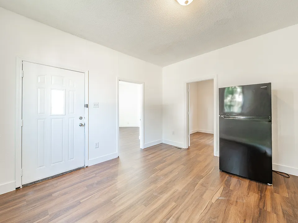View of front door, and bedroom and living room entrances from the kitchen.