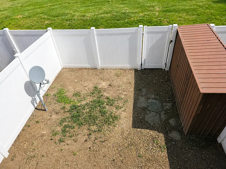 Sunny backyard with fenced yard and shed