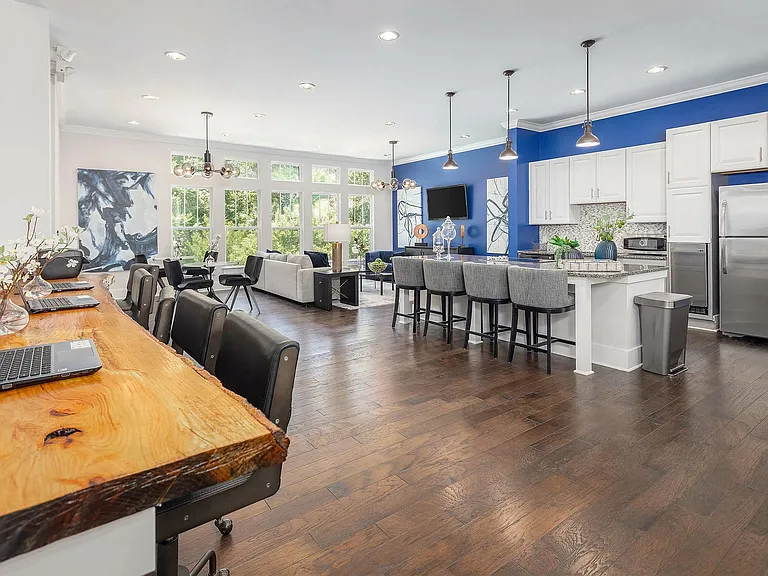 Modern resident clubhouse with coworking space, lounge seating, and fully equipped kitchenideal for work, socializing, and community living in Charlotte.