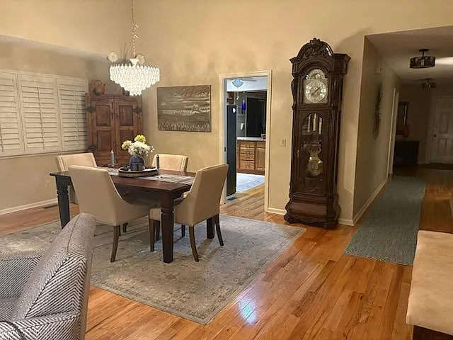 Dining area looking into large and bright kitchen.