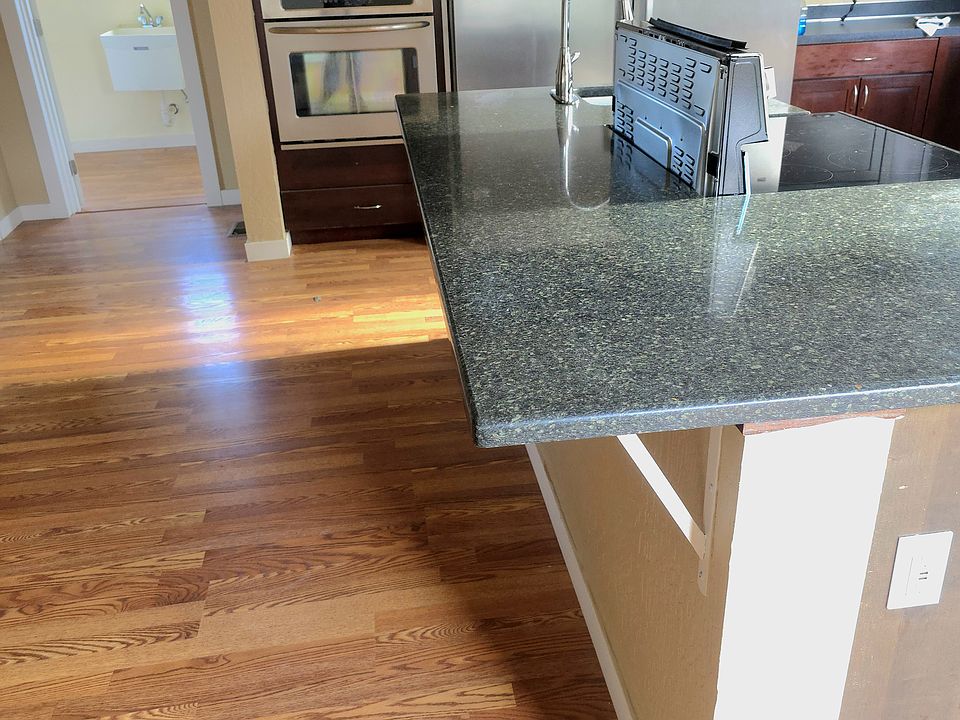 Photo of large granite island and bar area for sitting up to counter with added bar stools.