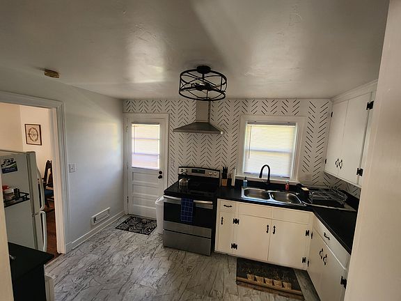Fully Furnished kitchen with stove, refrigerator, microwave, and more.