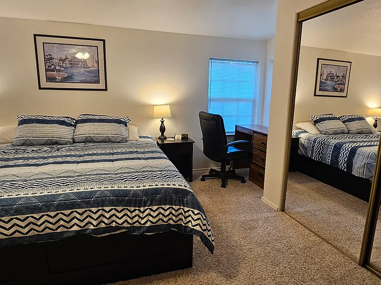 Bedroom with king size bed, and workspace.