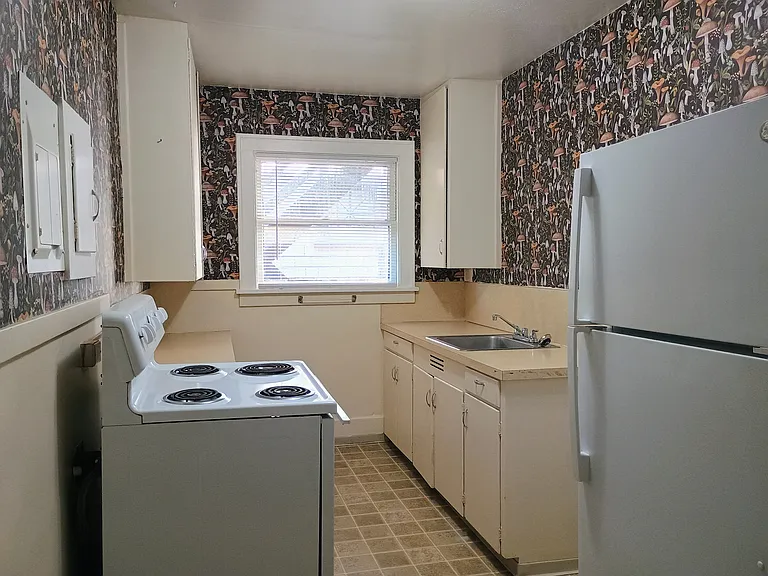 Kitchen furnished with an electric range/oven and a refrigerator/freezer.
